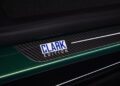 A close-up of a car door sill plate with a carbon fiber texture features the words "CLARK EDITION," highlighting the exclusive Jim Clark Edition of the Lotus Emira.