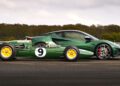 A classic green Lotus race car with yellow wheels is parked side by side with a modern Emira Jim Clark Edition—one of only 1-of-60—on a racetrack.