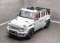 A white Mansory Convertible SUV with a partially open soft-top roof is parked in a minimalist, gray-walled showroom. The vehicle features large black rims and sporty exterior accents.