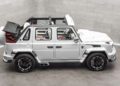 A white Speranza G-Class Convertible luxury SUV with its soft top partially open, featuring Mansory enhancements, is parked indoors on a concrete floor against a gray tiled wall.