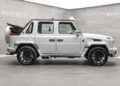 A white Speranza G-Class Convertible, expertly modified by Mansory with a soft top and black wheels, is displayed in a showroom.