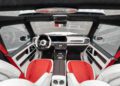 Interior view of a modern luxury car, such as the Speranza G-Class Convertible, featuring red and white leather seats, a digital dashboard, and carbon fiber accents.