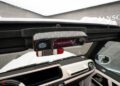 Interior view of a white luxury car customized by Mansory, showing the rearview mirror with Mansory branding and part of the sleek G-Class dashboard.