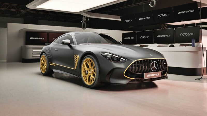 A matte black, limited-run Mercedes-AMG GT 63 with gold wheels and accents is parked in a modern, well-lit showroom.
