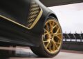 Close-up of the rear side of a limited-run Mercedes-AMG GT 63 with gold wheels and checkerboard detailing, parked next to a racetrack—perfect for fans eagerly awaiting the Brad Pitt F1 film.