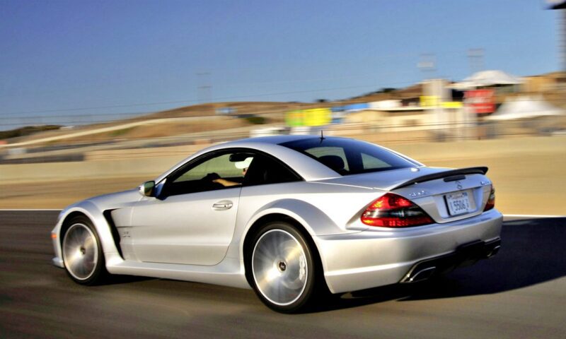 A silver sports car, the only Mercedes-AMG Black Series to feature a V12, speeds down a racetrack, its blurred background capturing the thrill of motion.