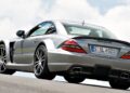 A silver Mercedes-Benz SL 65 AMG, the only Mercedes-AMG Black Series to feature a V12, is parked on an incline, viewed from the rear left side against a cloudy sky background.