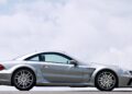 A silver sports car, the only Mercedes-AMG Black Series to feature a V12, is parked on a road with a cloudy sky in the background.