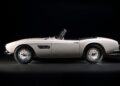 A classic white convertible sports car is shown in profile against a black background, capturing the spirit of How This BMW Went From Bold Gamble To Blue-Chip Classic.