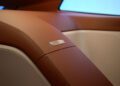 Close-up of a car interior featuring brown leather upholstery, beige trim, and a metallic badge labeled "Speedster," reminiscent of the refined luxury found in a classic BMW Shooting Brake.