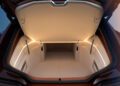 Open car trunk of a BMW Shooting Brake showing a spacious, well-lit storage compartment with beige interior and modern design, featuring side compartments and an elevated shelf.