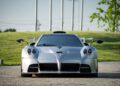 Front view of a silver Pagani Huayra Epitome sports car parked on a cobblestone surface with grass and trees in the background, reminiscent of an exclusive Villa d'Este setting.