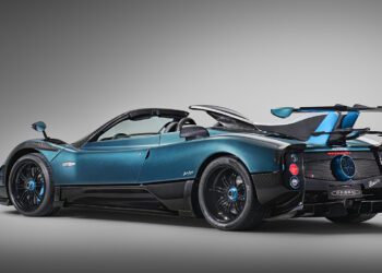 A blue and black Blue Carbon Zonda Roadster is shown angled from the rear, highlighting its aerodynamic design and carbon fiber details—a stunning 1-of-1 Pagani Unico masterpiece.