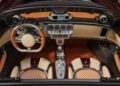 Overhead view of a luxury sports car interior featuring tan and brown leather seats, a metallic central console, and an array of analog gauges—capturing the essence of Pagani hypercars celebrated at Motor Valley Fest.