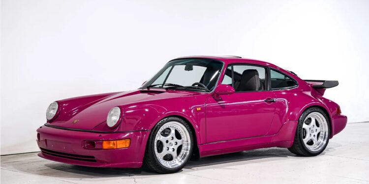 A magenta Porsche 911 Turbo with wide fenders and polished wheels is parked in a white studio setting, highlighting one of the most iconic Porsche models.