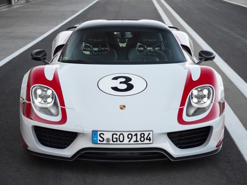 A white Porsche sports car with red accents, racing number 3 on the hood, and German license plate parked on a racetrack—a striking sight for any Comparison: Porsche Carrera GT Vs Porsche 918 Spyder enthusiast.