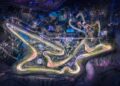 A nighttime aerial view of an illuminated racetrack with winding turns, including this upcoming F1 track’s opening corner 20 storeys up in the sky, surrounded by buildings, lights, and natural terrain.
