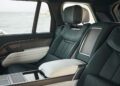 The image shows the luxurious leather interior of a Range Rover SV Carmel Edition’s backseat, featuring a large armrest and a window view of the ocean—perfect for those seeking exclusive Rovers for sale.