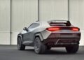 A matte gray Rezvani SUV with angular body lines and a prominent rear LED light bar is parked indoors against a large industrial wall, showcasing why here's what makes the Rezvani Knight an apocalypse-ready Lamborghini Urus rival.