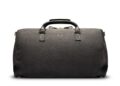 A black leather duffel bag with two handles, a small butterfly logo on the front, and reinforced leather corners—upgrade your style with this elegant piece. The perfect choice among luxury accessories, shown against a white background.