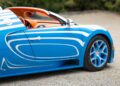 Close-up of a 1-of-1 Bugatti Veyron Grand Sport Vitesse in blue with white stripes, highlighting the side door, wheel, and a glimpse of the orange interior.