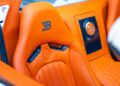 Close-up of an orange leather Bugatti Veyron Grand Sport Vitesse car seat with the Bugatti logo embossed on the headrest and back panel, highlighting its exclusive 1-of-1 craftsmanship.