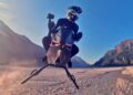A person wearing a helmet rides a hover bike over a dry, flat landscape with mountains in the background under a clear blue sky. No Wings No Rotors: So How Does The Volonaut Airbike Fly?.