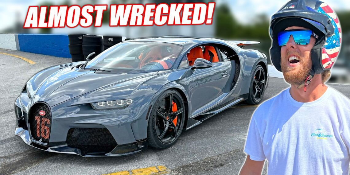 A man in a helmet stands near a gray Bugatti sports car at Freedom Factory racetrack with the text "ALMOST WRECKED!" above the car.