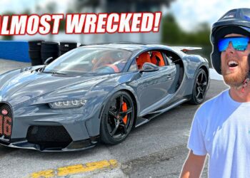 A man in a helmet stands near a gray Bugatti sports car at Freedom Factory racetrack with the text "ALMOST WRECKED!" above the car.