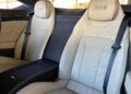 Two beige leather car seats with "Edition 8" branding on the headrests, separated by a center console, inside a modern vehicle.