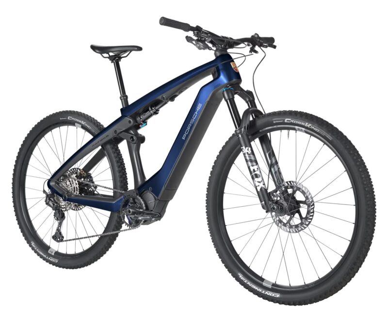 A modern electric mountain bike with a dark blue frame, front suspension, disc brakes, and the Porsche logo on the downtube—essential gear for any outdoor adventure.