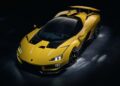 A yellow and black Lamborghini—Italy’s latest V12 supercar—sits parked indoors under dramatic lighting, highlighting its sharp, angular design, rear spoiler, and thrilling rear wheel drive.