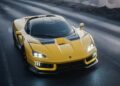 Italy’s latest V12 supercar, boasting quad turbos and 2100+ HP, sits with its headlights on—parked on a wet, dark road near a rocky edge, ready to unleash its rear wheel drive power.