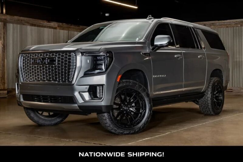 A gray GMC Yukon Denali luxury car with black wheels is parked indoors on a polished concrete floor. Text at the bottom reads "Nationwide Shipping!".