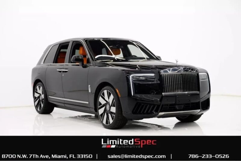 A luxury black SUV with chrome accents is displayed in a studio setting, shown from the front left angle—perfect for those seeking a luxury car for sale among top car listings.