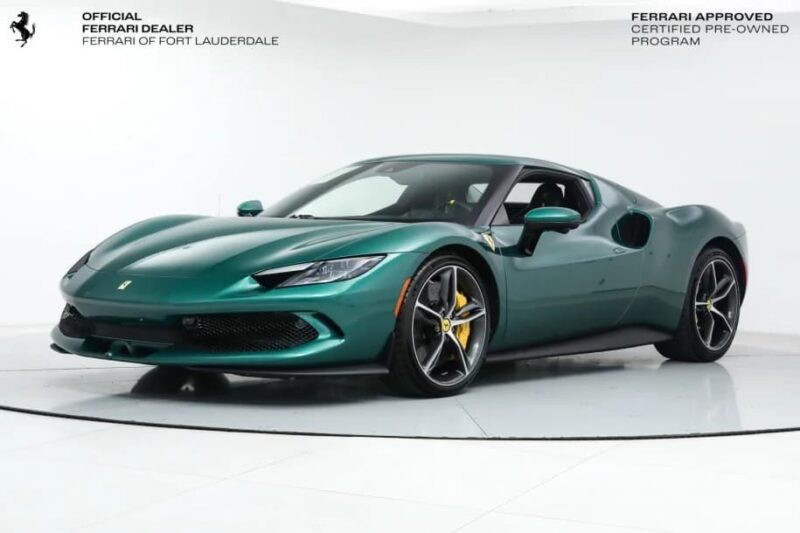A green Ferrari luxury car is displayed in a white showroom with dealership and certification text in the corners.
