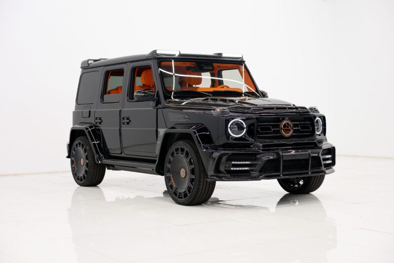 An exclusive 2025 Cullinan with orange interior accents is parked in a white, minimalistic room.