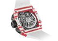 Close-up of the back of a Richard Mille RM 72-01 Chronograph with a red and white case, revealing its intricate mechanical movement and white strap—a style favored by Charles Leclerc.