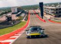 A silver Maserati from the track-focused lineup speeds around the Circuits of the Americas, with grandstands and pit buildings visible in the background.