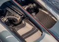 Close-up view of a Bugatti engine bay with carbon fiber components and detailed engineering, captured during a Tourbillon showcase at the Washington D.C. showroom.