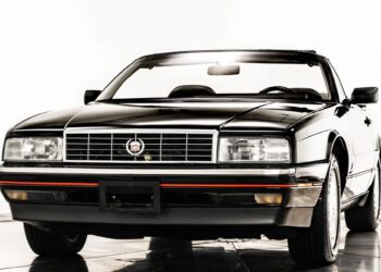 A black Cadillac Allanté convertible, a standout among luxury cars, is shown from the front against a white background.