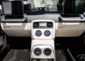 Rear seat view of a luxury Mercedes-Maybach G650 For Sale interior, featuring beige and black leather, dual center vents, two screens, and air controls.