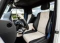 The interior of a Mercedes-Maybach G650 For Sale features diamond-stitched beige and black leather seats, a sleek black dashboard, and a luxurious steering wheel, all viewed from the driver’s side door.