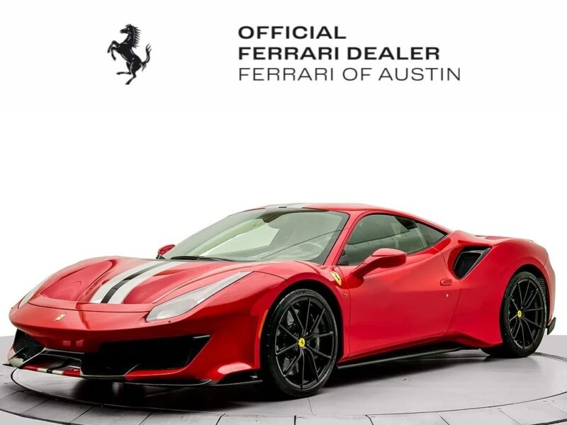 A red Ferrari 488 Pista sports car with black and white racing stripes, displayed in a showroom with the Ferrari of Austin official dealer logo above—a stunning, track-ready Ferrari for sale.