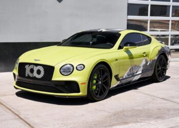 A lime green Bentley Continental GT, one of the best Bentleys, is parked on a concrete surface in front of a modern building with glass-panel garage doors.