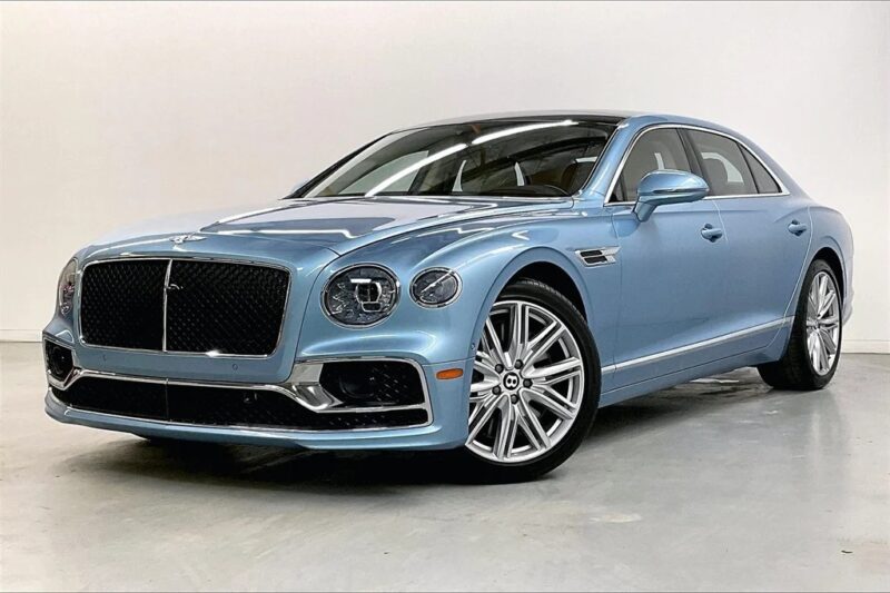 A light blue luxury Bentley sedan with chrome accents and large alloy wheels, photographed in a well-lit indoor studio with a plain background—an exceptional choice among the best Bentleys for sale.