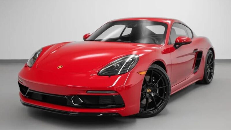 A red sports car with black wheels is parked in a clean, white indoor space. For sale: best sports car under $100k.