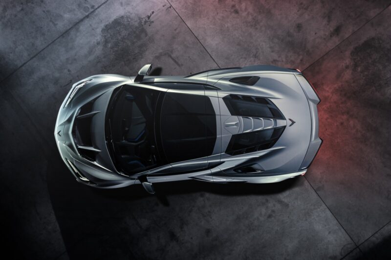 Overhead view of a silver sports car parked on a concrete floor, showcasing its aerodynamic design and dark-tinted windows. Revealed: 2026 Corvette ZR1X is the most powerful Chevrolet ever built.