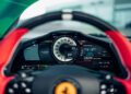 Close-up view of a Ferrari 296 GTS dashboard—a modern tribute—showing a central tachometer, digital displays, and gauges behind the steering wheel.