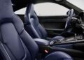 Interior of a modern Porsche sports car featuring blue leather seats, a center console with controls, and a digital dashboard.